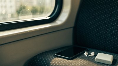 Celular e fones no banco de um trem urbano