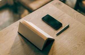 携帯電話とペンの横には、卓上カレンダーが置かれている。