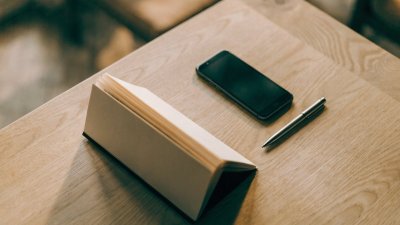 Calendário de mesa ao lado de um celular e uma caneta